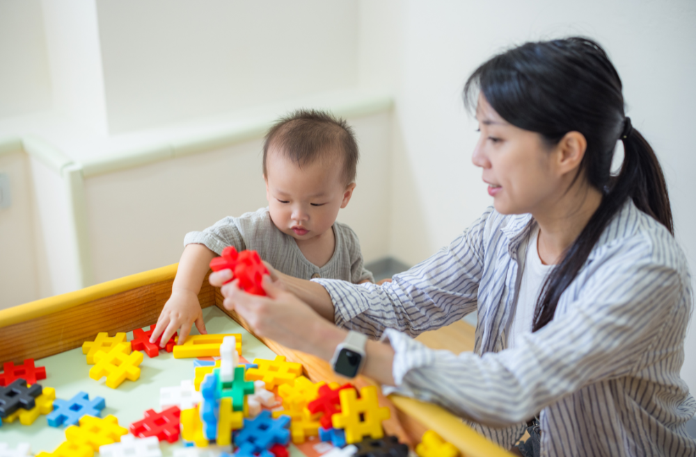 toddler and mother playing with puzzles