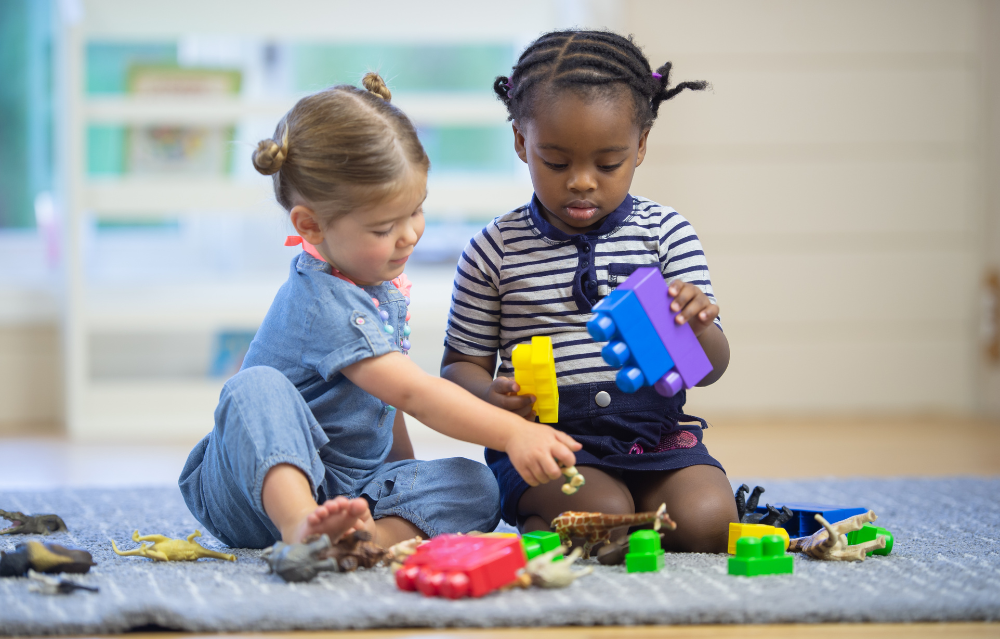 two toddlers playing with lego