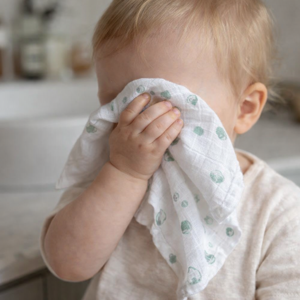 baby wiping face with muslin