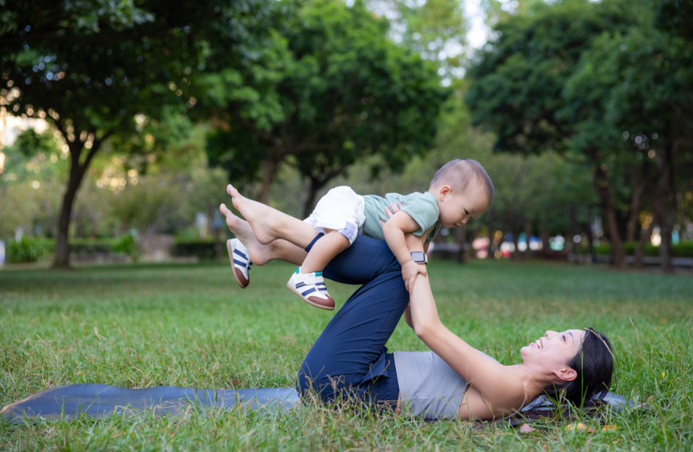 mother lifting baby up with her legs