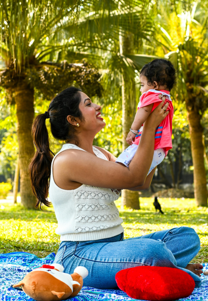 mother lifting baby up in the air outdoors