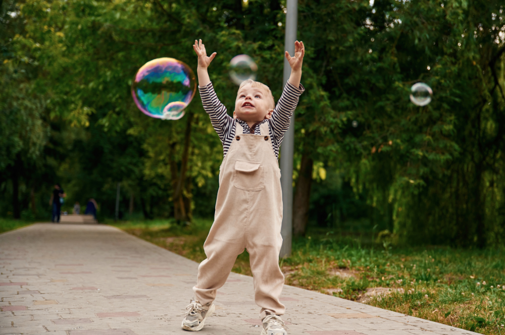 toddler chasing bubbles