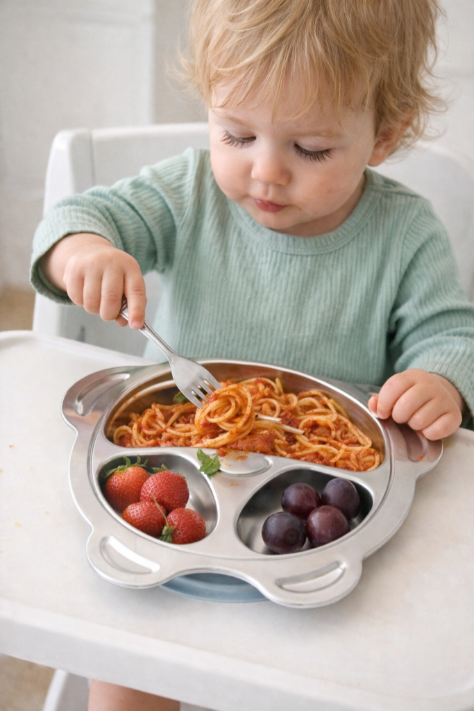 toddler eating from stainless steel plate