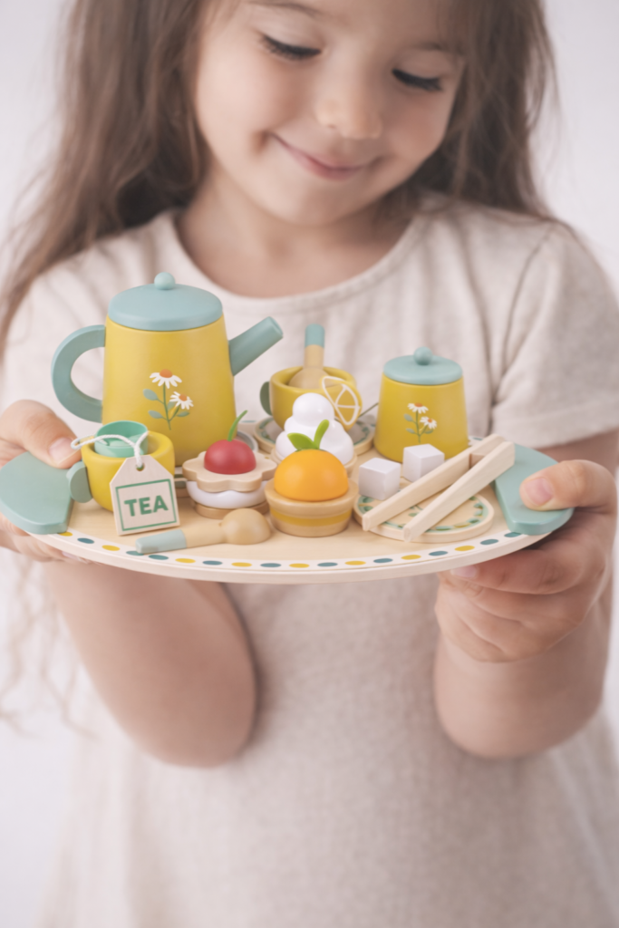 toddler with a pretend tea set