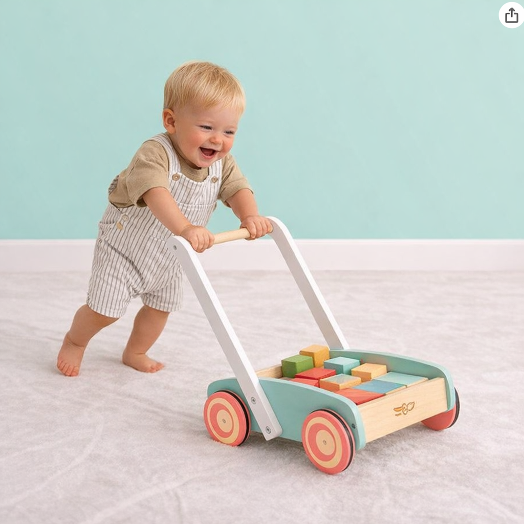 toddler pushing a wooden cart