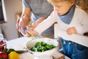 toddler helping mum in the kitchen on a folding learning tower