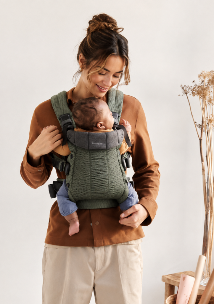 Parent wearing BabyBjörn Harmony baby carrier indoors