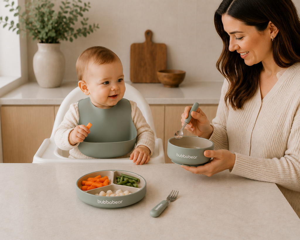 Baby using the Bubba Bear porcelain weaning set with suction plate, bowl and child-sized cutlery during baby-led weaning.