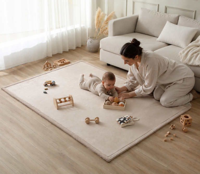 Mother and baby playing on a beautiful playmat that looks like a rug