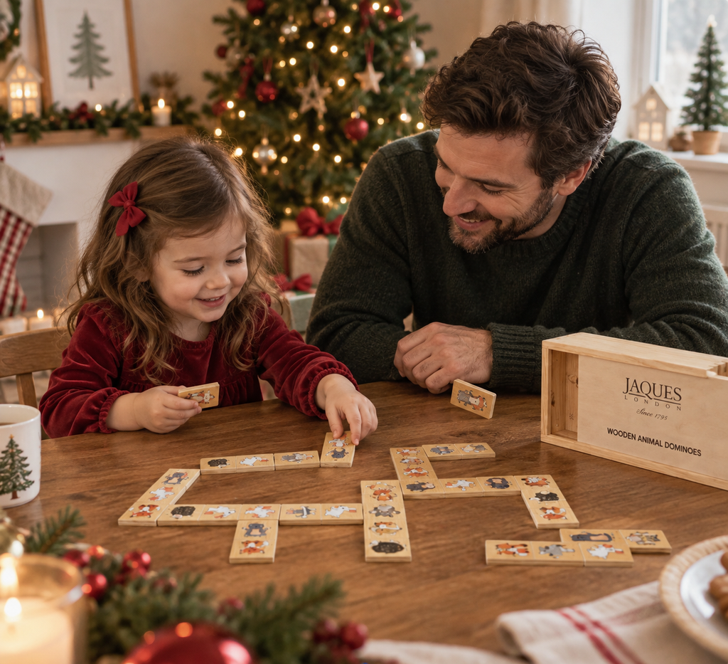 Father and daughter playing wooden animal dominoes at Christmas.