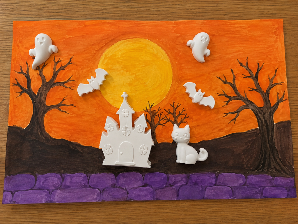 Halloween plaster figurines that we added on paper that we drew.